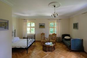 a living room with a bed and a chair at Pałac w Dolsku in Dolsk
