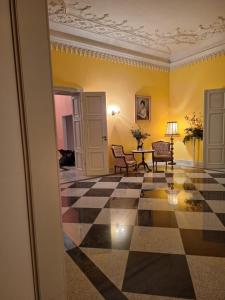a room with a checkerboard floor and yellow walls at Pałac w Dolsku in Dolsk