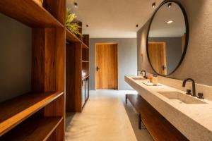 a bathroom with two sinks and a large mirror at Kamai Pousada Boutique in Pôrto de Pedras +17 photos