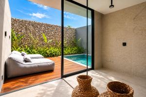 a room with a view of a pool and a couch at Kamai Pousada Boutique in Pôrto de Pedras