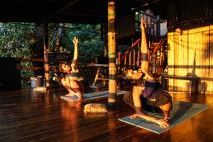 two women doing yoga on the floor in a gym at El Bosque Minca in Minca