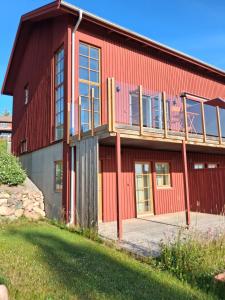 a red barn with a balcony on the side of it at Sjöutsikt med bastu som tillval in Tällberg