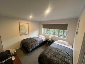 a bedroom with two beds and a window at Pohara Retreat in Pohara