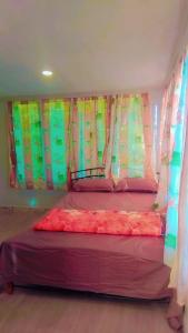 a bed in a room with colorful curtains at Riverside Holiday Arartment in Sigatoka