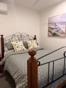 a bedroom with a bed and a painting on the wall at Valley View House in Gympie