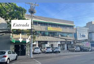 a building with cars parked on the side of a street at Pituba Suítes in Salvador
