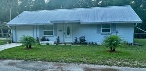 a white house with two palm trees in front of it at Natures Nest #2 in Homosassa
