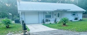 a small white house with a driveway in front of it at Natures Nest #2 in Homosassa
