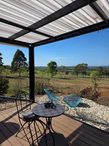 a patio with a table and chairs on a deck at Whispering Vines in Lovedale