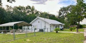 a white building with a fence in front of it at Natures Nest #2 in Homosassa