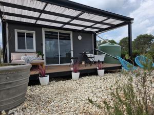 a tiny house with a pergola and plants at Whispering Vines in Lovedale