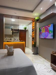 a bedroom with a bed and a tv on a wall at Ilha Bela Flat Alter do Chão in Santarém
