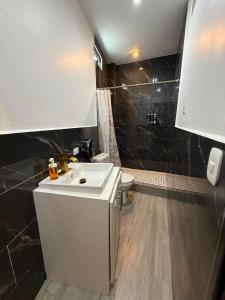 a bathroom with a white sink and a toilet at Hotel Gods Blessing in Nebaj