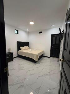a bedroom with a bed and a marble floor at Hotel Gods Blessing in Nebaj