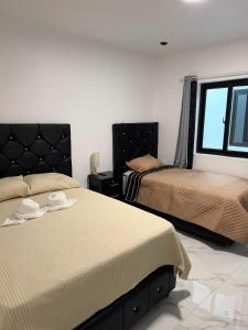 a bedroom with two beds and a window at Hotel Gods Blessing in Nebaj