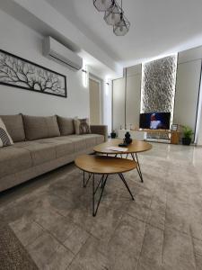a living room with a couch and two tables at Aura apartment in Petrovec