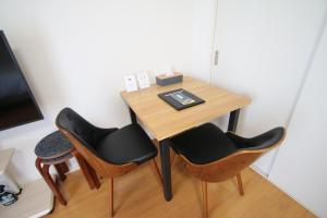 a small table with two chairs and a desk at オンブラージュ704号室-無料駐車場付き-繁華街まで徒歩圏内-南向きで明るいワンルーム in Kumamoto