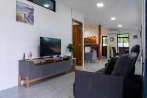 a living room with a flat screen tv on a cabinet at Fernando's Bungalow in Puerto Ayora