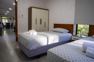 a bedroom with two beds and a large window at Fernando's Bungalow in Puerto Ayora