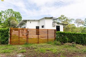 a white house behind a wooden fence at Fernando's Bungalow in Puerto Ayora