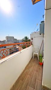 a balcony with a white railing and a chair on a roof at Rooftop Treehouse - Hammam Sousse in Sousse