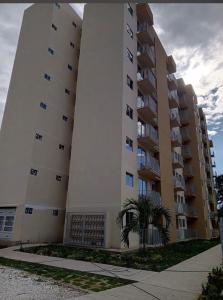 a large apartment building with a palm tree in front of it at Aparta Hotel Casacrislaye Santa marta in Santa Marta