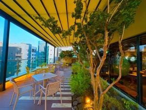a patio with tables and chairs on a building at 대구 이스턴호텔 라이온즈파크점 in Daegu
