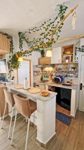 a kitchen with a large white island with chairs at Rooftop Treehouse - Hammam Sousse in Sousse +7 photos