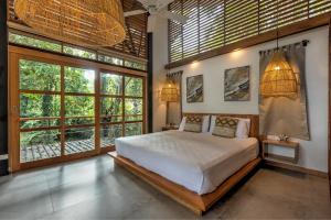 a bedroom with a large bed and large windows at Porto Alegre Villas in Punta Uva +29 photos