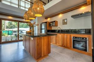 a large kitchen with wooden cabinets and a counter top at Porto Alegre Villas in Punta Uva