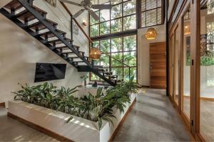 a living room with a staircase and plants at Porto Alegre Villas in Punta Uva