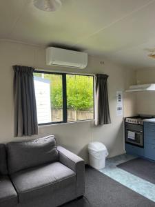 a living room with a couch and a window at Stratford Motel & Holiday Park in Stratford