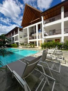 a resort with chairs and a swimming pool at Paraiso Destiny Duplex in Bayahibe