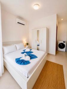 two swans sitting on a white bed in a bedroom at Paraiso Destiny Duplex in Bayahibe