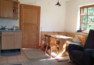 a kitchen with a table and a door in a room at Ruhige Wohnung im Grünen Lichtenwald in Thomashardt +12 photos