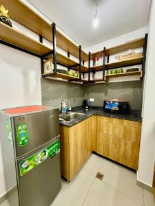 a kitchen with a stainless steel refrigerator and wooden cabinets at monoambiente manu in Trinidad