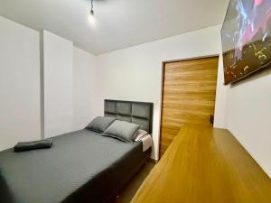 a bedroom with a bed and a wooden door at monoambiente manu in Trinidad