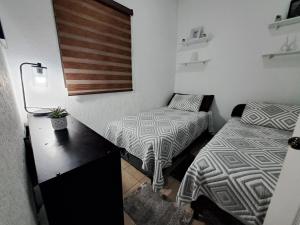 a small room with two beds and a desk with a lamp at The terrazzo house in Santa Ana