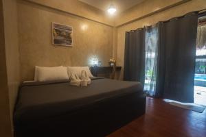 a bedroom with a bed with two shoes on it at Azarria Siargao Villas in General Luna