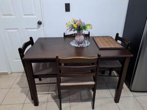 a dining room table with a vase of flowers on it at The terrazzo house in Santa Ana