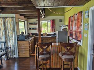 a kitchen with a table and two bar chairs at Southern Sunset Villa in Choiseul