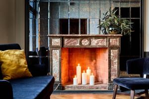 a fireplace with three candles in a living room at Liberté 33, an Ascend Collection Hotel in Poznań