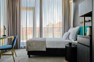 a hotel room with a bed and a large window at Liberté 33, an Ascend Collection Hotel in Poznań +112 photos