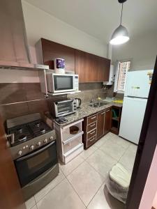 a small kitchen with a stove and a microwave at Consorcio San Ignacio in San Juan