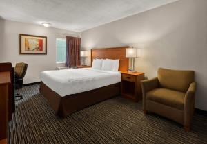 a hotel room with a bed and a chair at Park Inn by Radisson, Detroit Metro Airport in Romulus