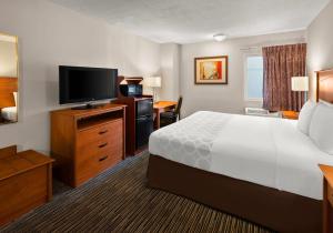 a hotel room with a bed and a flat screen tv at Park Inn by Radisson, Detroit Metro Airport in Romulus