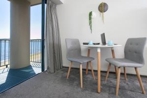 a table and two chairs in a room with a balcony at Boulevard Waters in Taupo