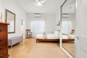 a bedroom with a bed and a mirror at Stockton Coastal Escape in Stockton