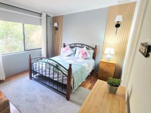 a bedroom with a bed with pink pillows on it at Homestay in Coogee
