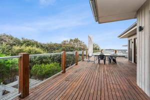 a wooden deck with a table and chairs on it at 9 Doors From Front Beach in Point Lonsdale